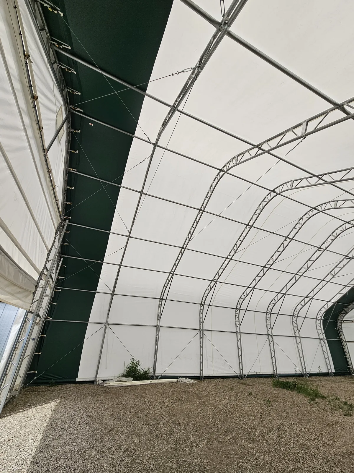 Interior trusses and bracing beneath a white fabric cover