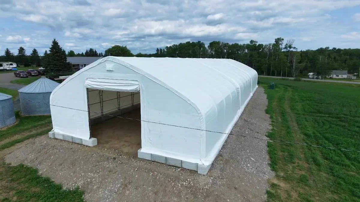 Front view of a white covered building on the farm site