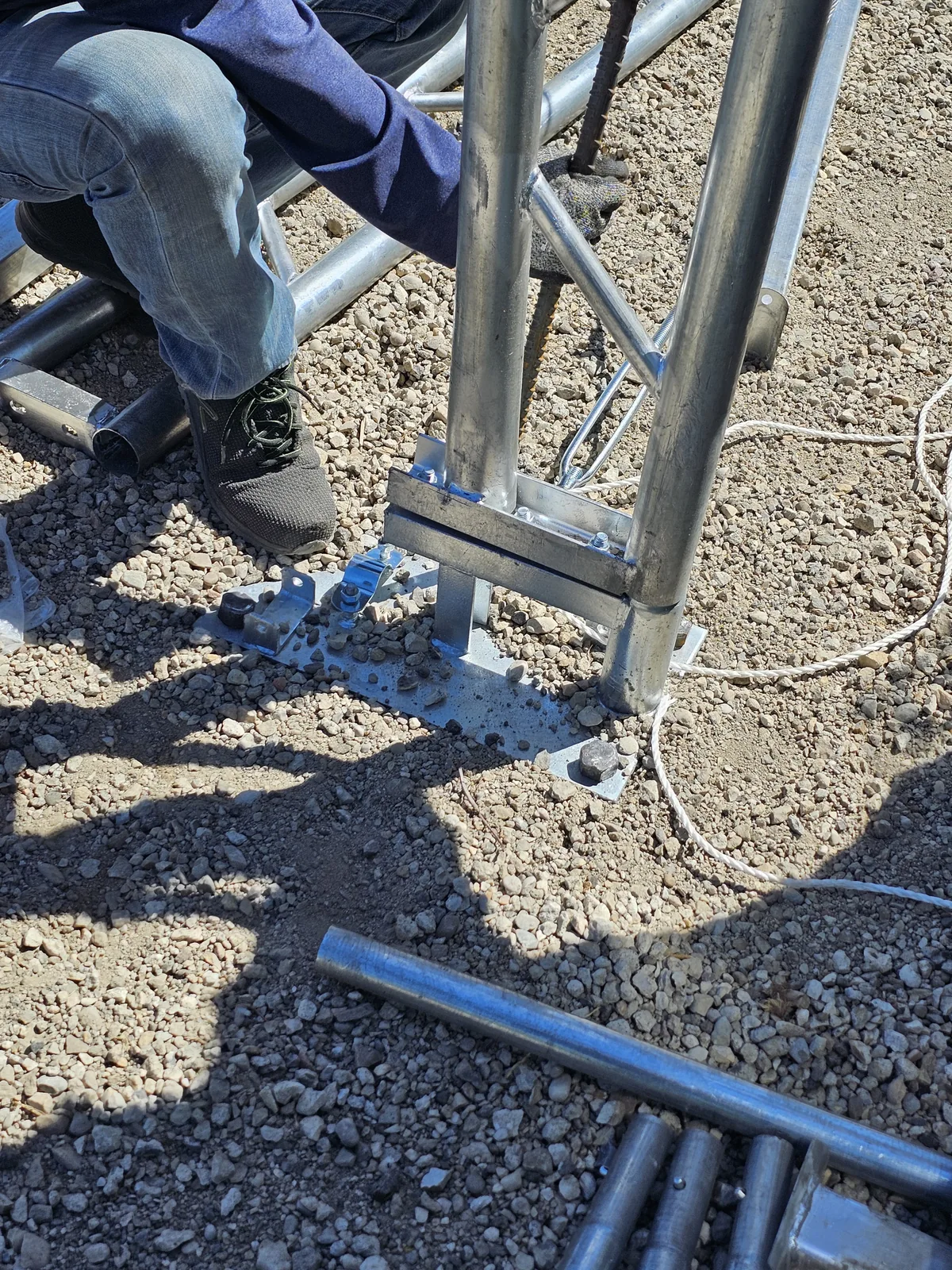 Installer working at the base connection of a steel truss