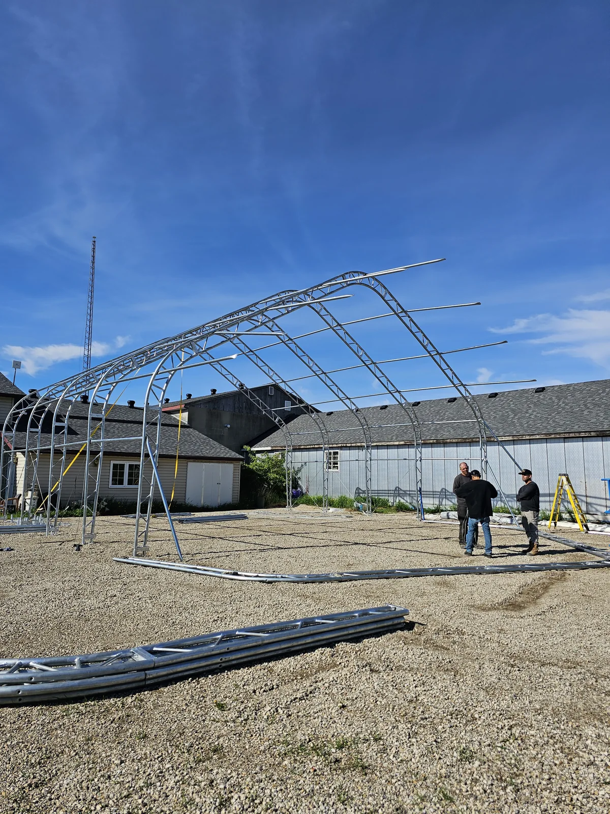 Crew beside a partially assembled steel building frame